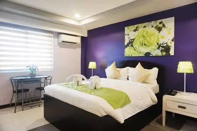 a bedroom with a large bed with a purple wall at AMORE HOTEL MANILA in Manila