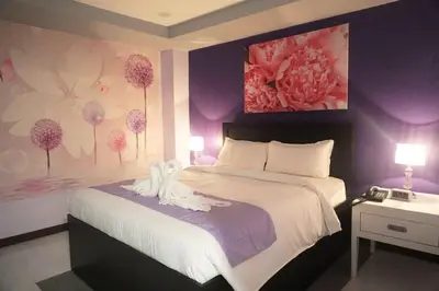 a bedroom with a bed with two swans on it at AMORE HOTEL MANILA in Manila