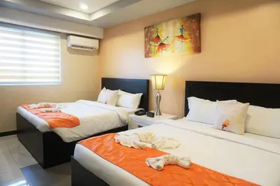 two beds in a hotel room with babies laying on them at AMORE HOTEL MANILA in Manila
