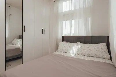 a bedroom with white walls and a bed with a mirror at Modern Luxe Condo Unit in Cavite in Imus