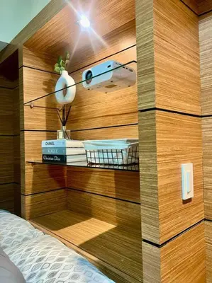 a bedroom with a wooden wall with a bed and a lamp at PSV NAIA T3 - Month of January - New Year 2026 PROMO Php 1,999 - 1 BR Interior Designed Unit in Manila