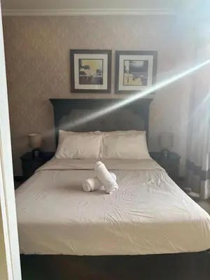 a bed with a white towel on top of it at Gramercy Residences 46th Floor 1 Bedroom Sunset View in Manila