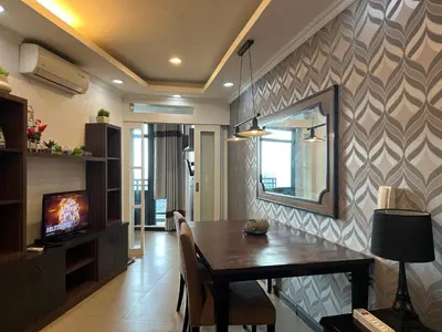 a dining room with a table and a mirror at Gramercy Residences 46th Floor 1 Bedroom Sunset View in Manila