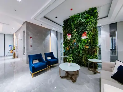 a large green wall with blue chairs and tables in a lobby at 1BR Condotel Suite at Sunshine100 City Plaza #SS01 in Manila