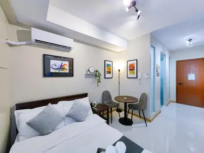 a bedroom with a bed and a table and chairs at 1BR Condotel Suite at Sunshine100 City Plaza #SS01 in Manila