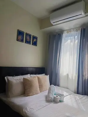 a bedroom with a white bed with a window at JN Staycation at Shore 3 Mall of Asia in Manila