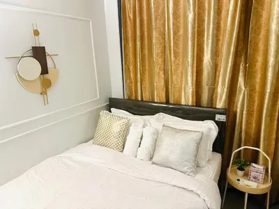 a bedroom with a bed with white sheets and pillows at Mid-Century Extent Condo Unit @ Shore 2, MOA in Manila