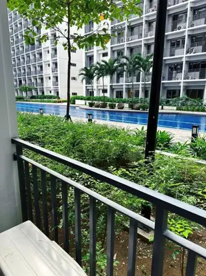 a balcony with a view of a large building at Mid-Century Extent Condo Unit @ Shore 2, MOA in Manila