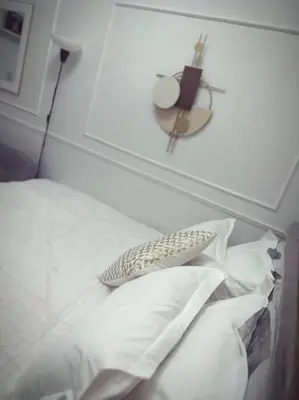 a white bed with a pillow and a picture on the wall at Mid-Century Extent Condo Unit @ Shore 2, MOA in Manila