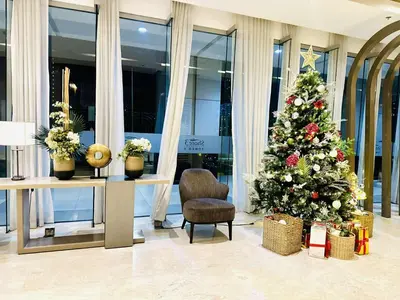 a christmas tree in a lobby with a chair at Mid-Century Extent Condo Unit @ Shore 2, MOA in Manila