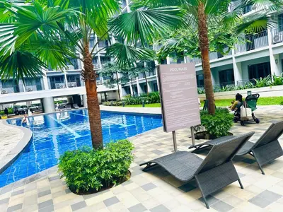 a sign in front of a swimming pool with palm trees at Scandi-Style & Organic condo Shore 3 MOA in Manila