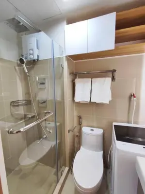 a bathroom with a toilet and a glass shower at Scandi-Style & Organic condo Shore 3 MOA in Manila
