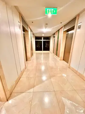 an empty hallway of an office building with an exit sign at Mandaluyong Staycation in Manila
