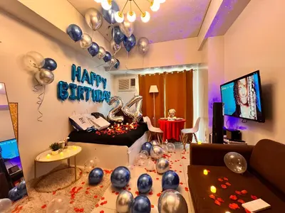 a living room with a happy birthday sign and balloons at Mandaluyong Staycation in Manila