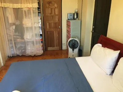 a bedroom with a bed and a fan in it at Guesthouse Cavite in Dasmariñas