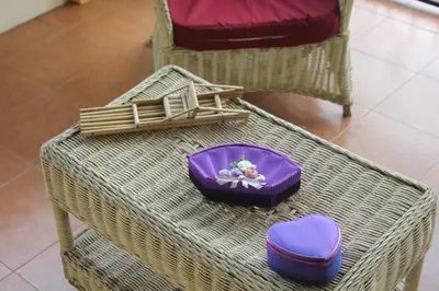 a wicker table with a purple bowl on top of it at Guesthouse Cavite in Dasmariñas