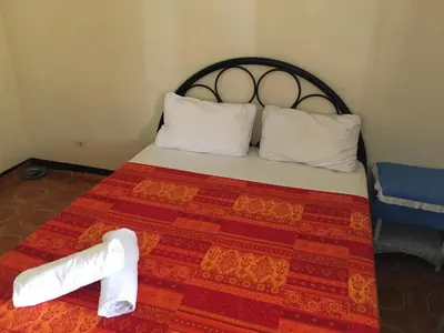 a bed with two white pillows and a red blanket at Guesthouse Cavite in Dasmariñas