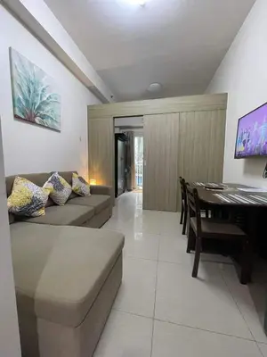 a living room with a couch and a table at Shore Residence Mall of Asia Direct pool in Manila