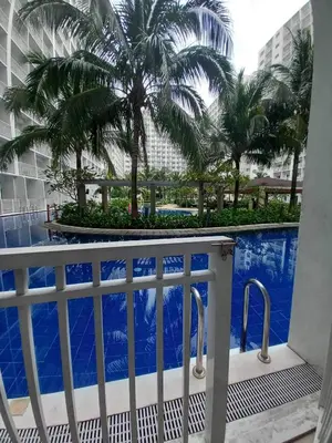 a view from the balcony of a hotel with palm trees at Shore Residence Mall of Asia Direct pool in Manila