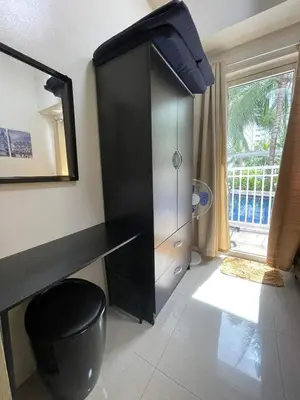 a black cabinet in a room with a mirror at Shore Residence Mall of Asia Direct pool in Manila