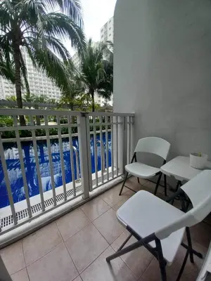 a balcony with chairs and a view of the ocean at Shore Residence Mall of Asia Direct pool in Manila