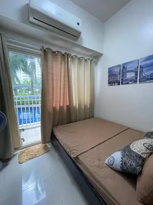 a bedroom with a bed and a window at Shore Residence Mall of Asia Direct pool in Manila