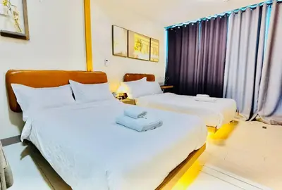 a hotel room with two beds with white sheets at Thompson Suites - 2 beds, One Uptown Residences - XBOX & Netflix in Manila
