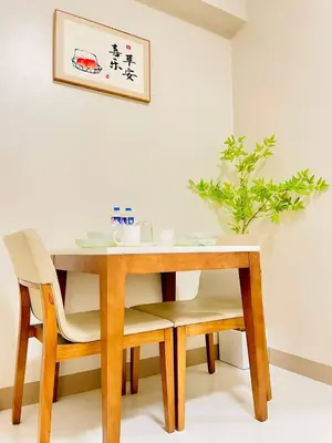 a wooden table with two chairs and a plant on the wall at Thompson Suites - 2 beds, One Uptown Residences - XBOX & Netflix in Manila