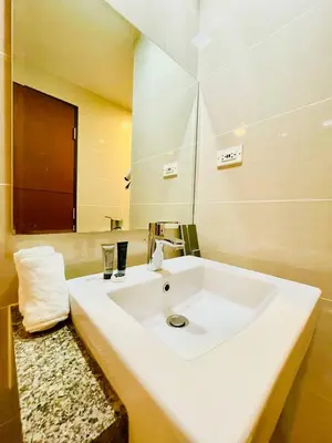 a bathroom with a white sink and a mirror at Thompson Suites - 2 beds, One Uptown Residences - XBOX & Netflix in Manila