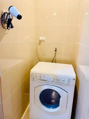 a washing machine in a corner of a bathroom at Thompson Suites - 2 beds, One Uptown Residences - XBOX & Netflix in Manila