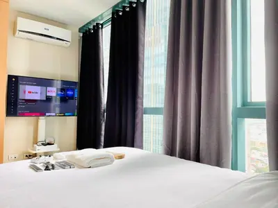 a bedroom with a white bed and a window at Thompson Suites - 2 beds, One Uptown Residences - XBOX & Netflix in Manila
