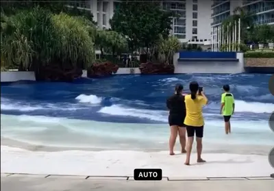 three people standing on the beach looking at the water at Azure Condo 1BR Next to Mall, Near City & Airport in Manila