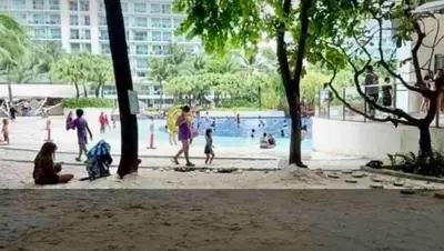 a group of people playing in a pool in a park at Azure Condo 1BR Next to Mall, Near City & Airport in Manila
