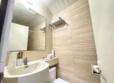 a bathroom with a sink and a toilet and a mirror at ADB AVENUE TOWER in Manila