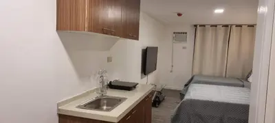 a small room with a sink and a bed at ADB AVENUE TOWER in Manila