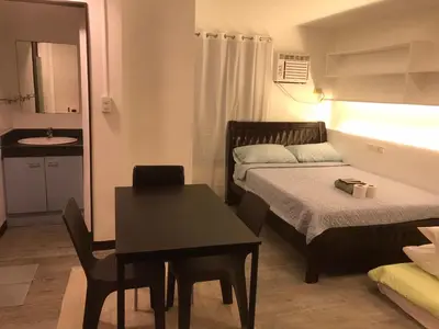 a small room with a table and a bed and a desk at ADB AVENUE TOWER in Manila