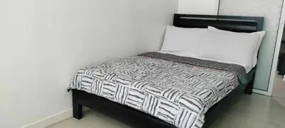 a small bed with a black and white comforter and pillows at Staycation at Azure Urban Resorts in Manila