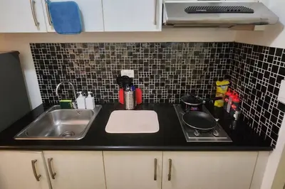 a kitchen counter with a sink and a stove at Great View in Makati in Manila