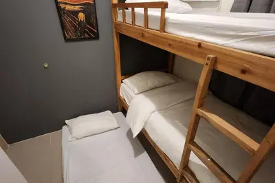 two bunk beds in a small room with a smaller bed at Homey 2br apartment in Makati in Manila
