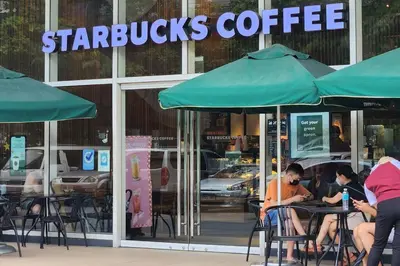 people sitting at tables in front of a starbucks coffee shop at Homey 2br apartment in Makati in Manila