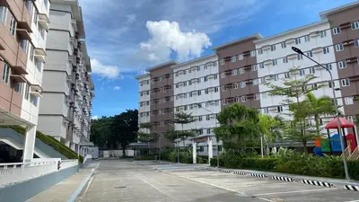 an empty street in front of apartment buildings at Studio Type Condominum at SMDC HOPE Residences in Trece Martires