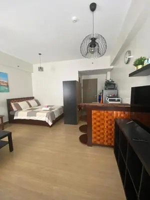 a bedroom with a bed and a television in it at Studio Type Condominum at SMDC HOPE Residences in Trece Martires