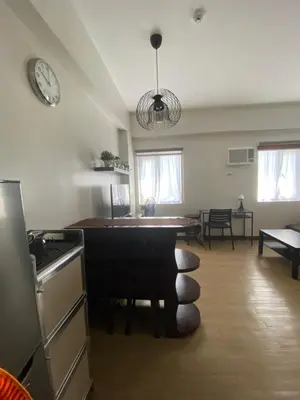 a kitchen with a table and a clock on the wall at Studio Type Condominum at SMDC HOPE Residences in Trece Martires