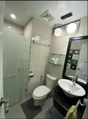 a bathroom with a toilet and a sink and a shower at One Palm Tree Villas Near NAIA3 in Manila