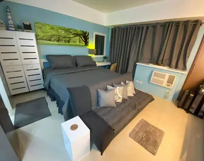 a bedroom with a bed and a couch at One Palm Tree Villas Near NAIA3 in Manila