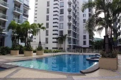a swimming pool in front of a building at One Palm Tree Villas Near NAIA3 in Manila