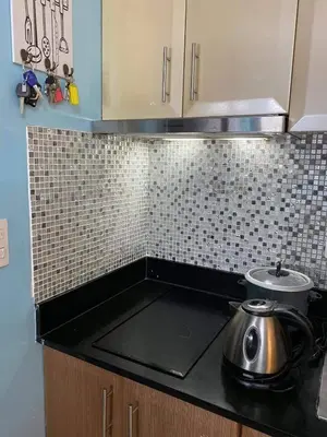 a kitchen counter with a tea pot on the stove at One Palm Tree Villas Near NAIA3 in Manila