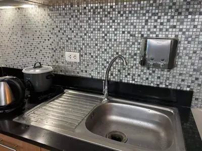 a stainless steel sink in a kitchen with a counter at One Palm Tree Villas Near NAIA3 in Manila