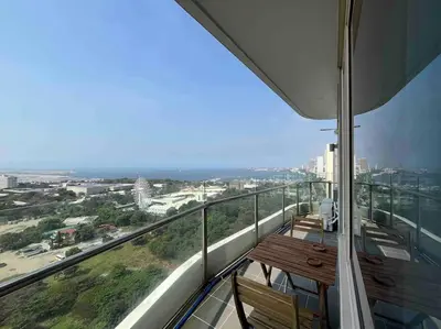 a balcony with a wooden table and a view of a city at Coast of Finland: Stunning Manila Bay & Sunset in Manila