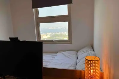 a bed in a room with a window and a television at Coast of Finland: Stunning Manila Bay & Sunset in Manila